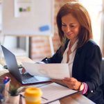 Image of businesswoman reviewing papers at her desk