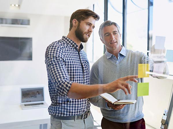 Two men working with post-it notes